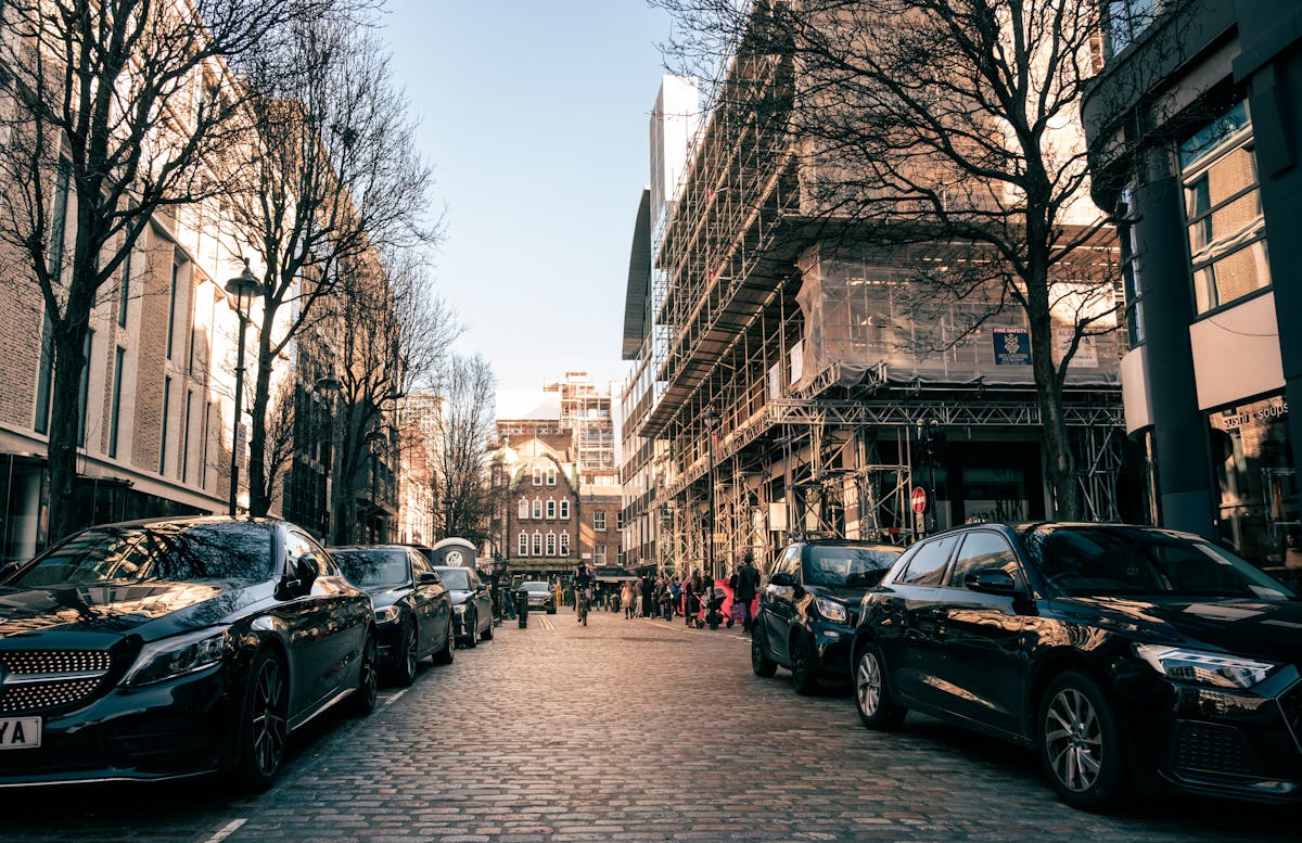 Urban scene on a London cobblestone street with architecture and parked cars