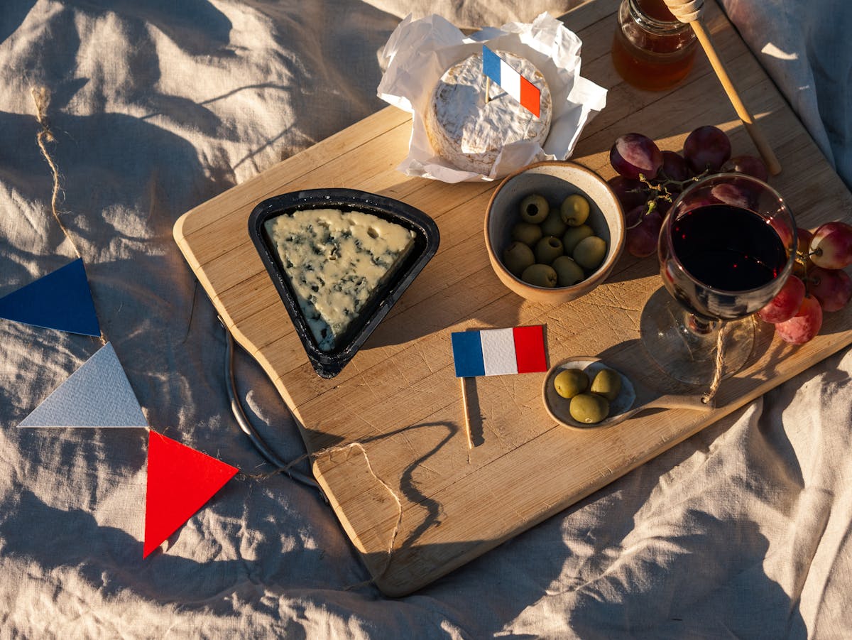 French picnic with wine, cheese, and grapes on a wooden board