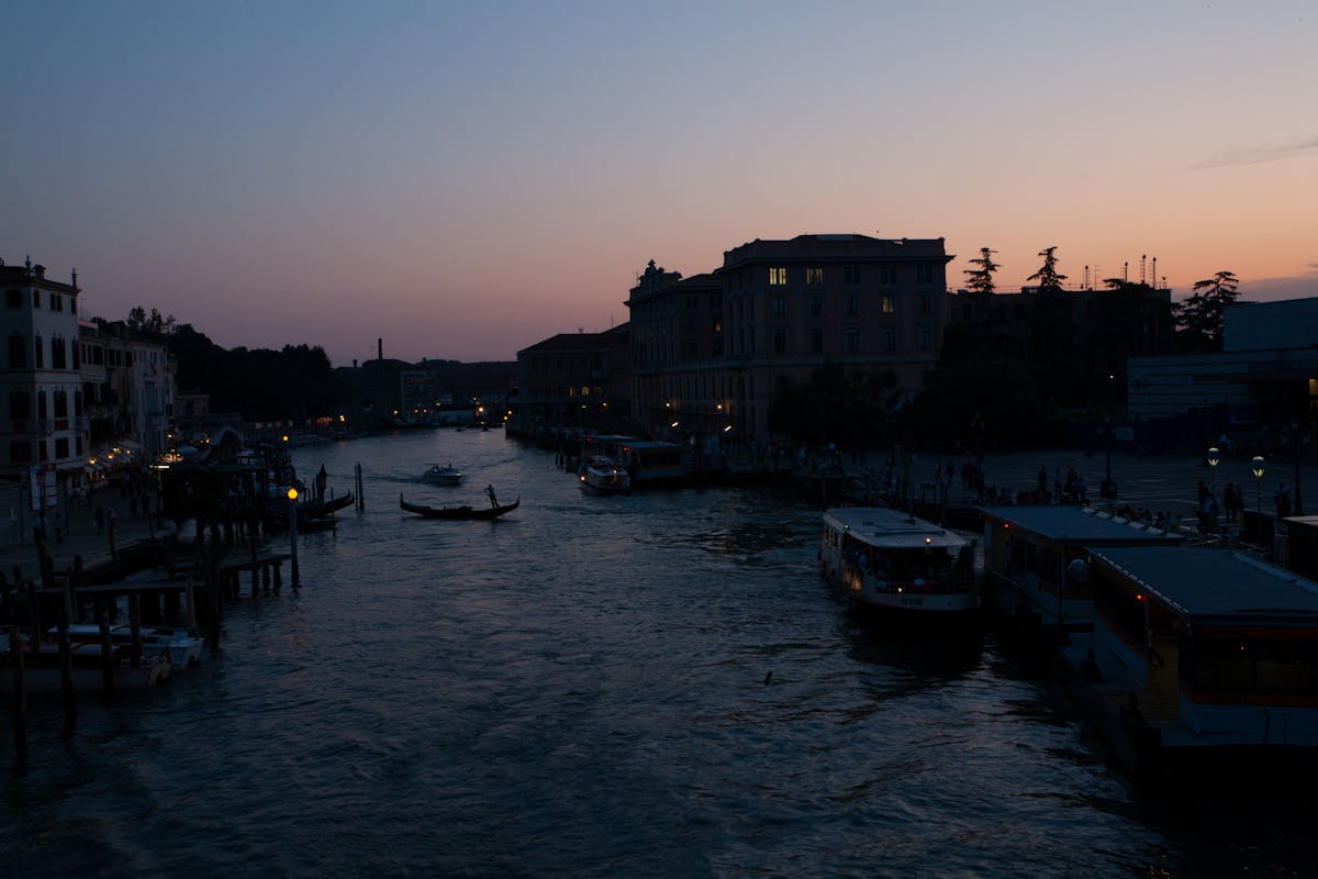 Venetian canal at twilight with gondolas and historic architecture