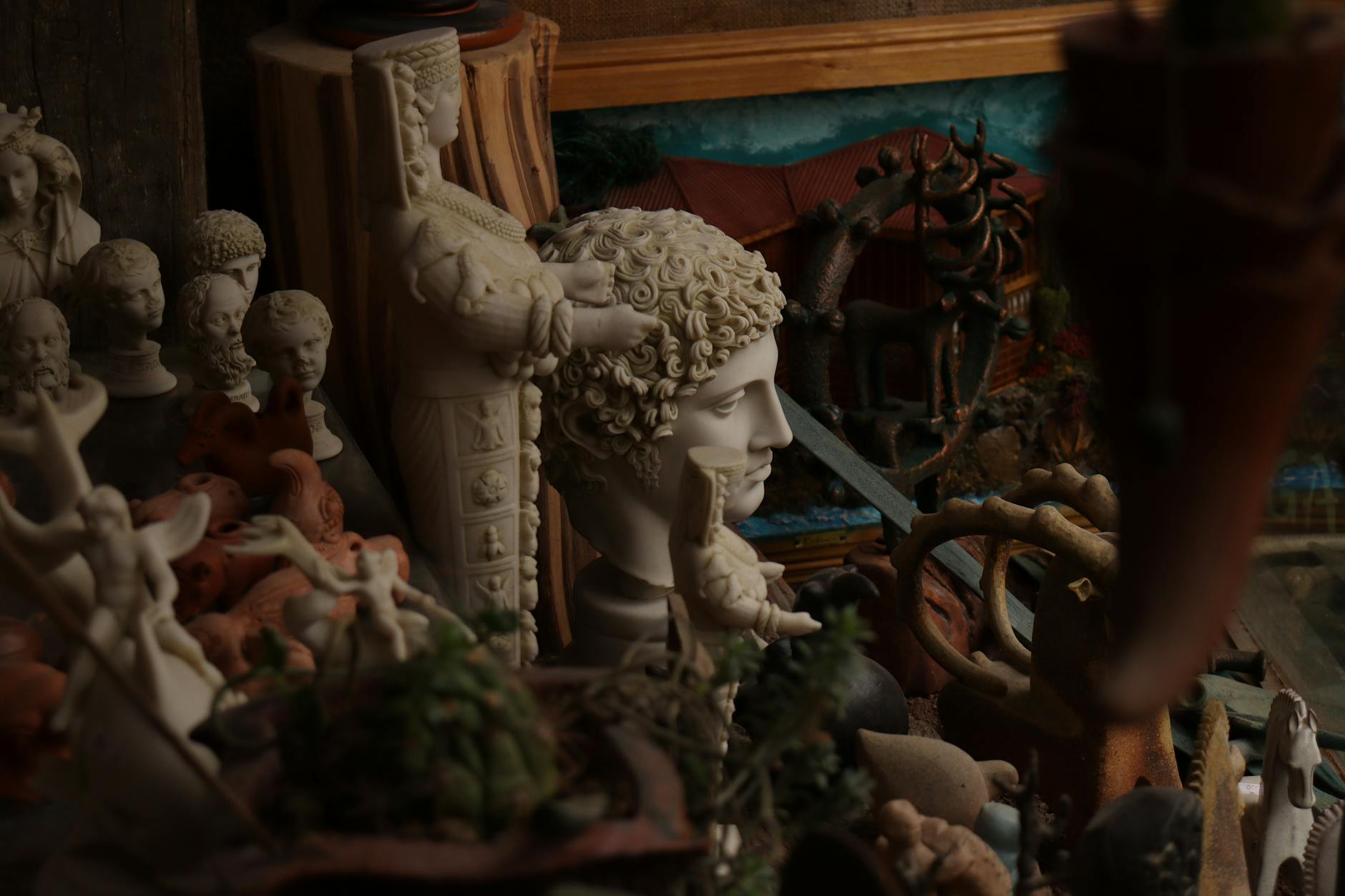 Collection of ancient Greek sculptures and artifacts displayed in museum lighting