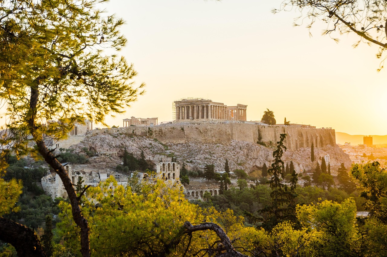 Athens cityscape at sunset with the Acropolis illuminated against warm sky