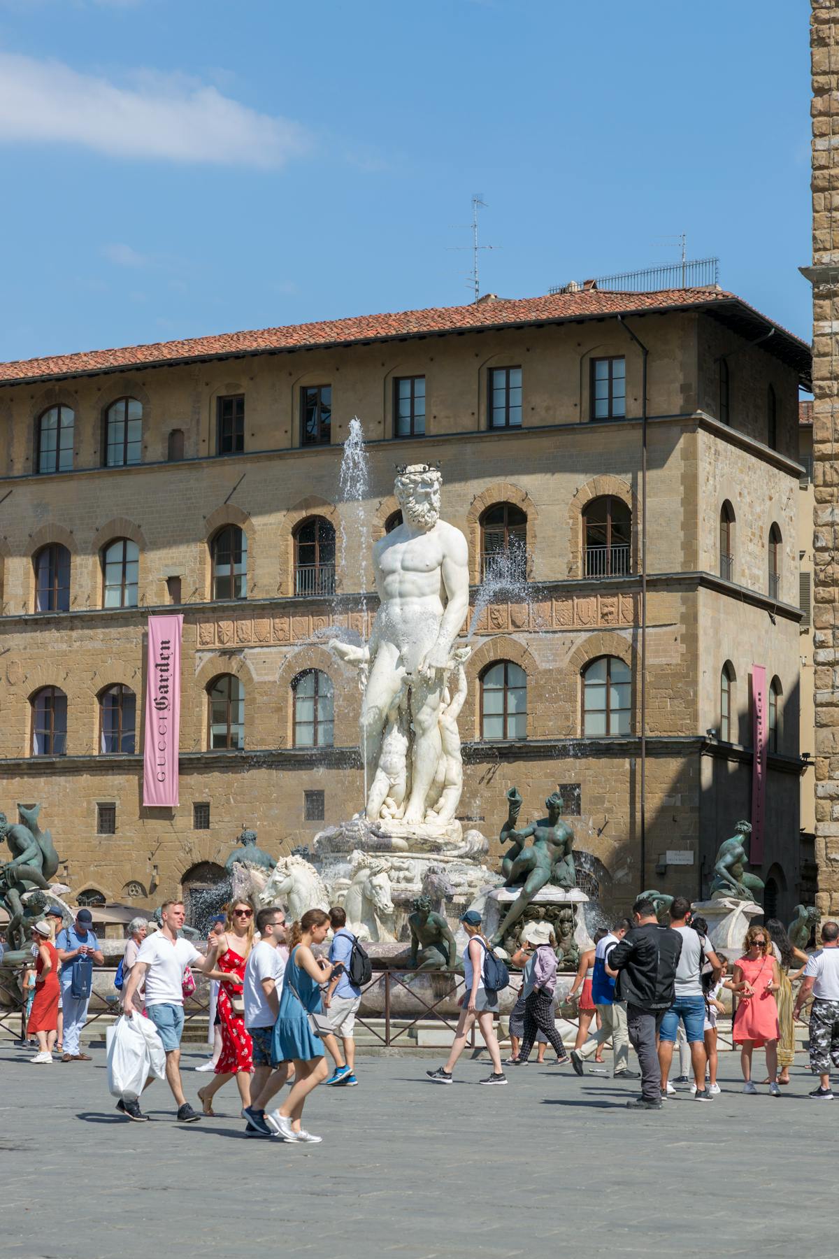 The Neptune Fountain in Piazza della Signoria Florence with travelers walking past