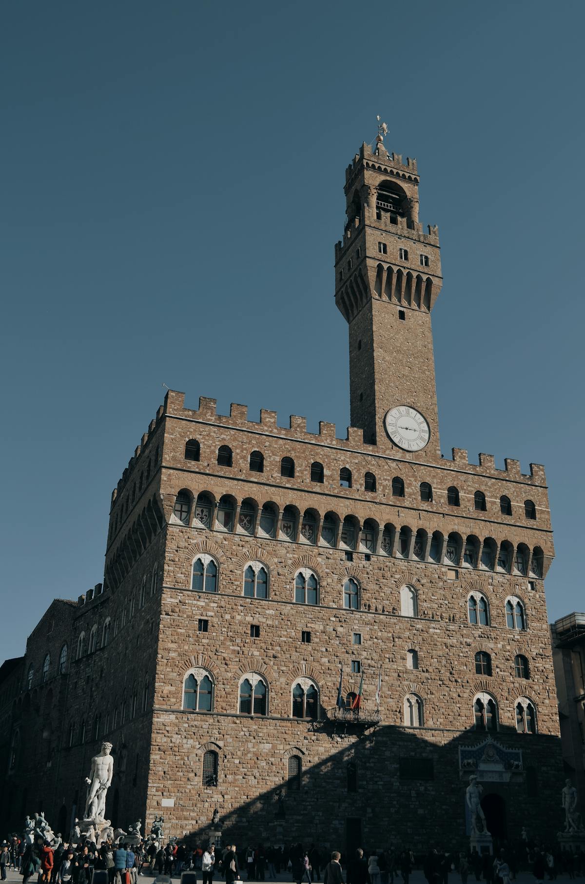 Palazzo Vecchio standing tall against a clear blue sky in Florence