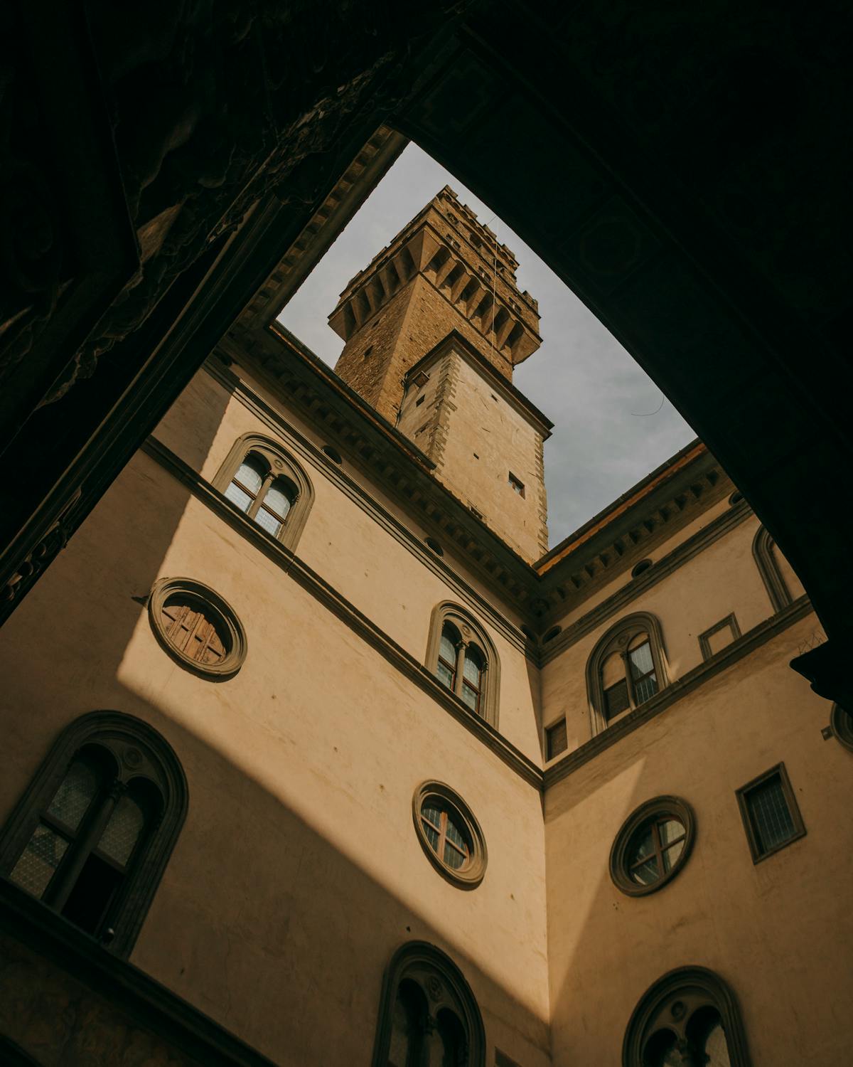 View of Palazzo Vecchio tower framed by stone arches in Florence Italy