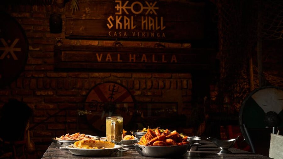 A rustic medieval-style feasting hall set with traditional dishes