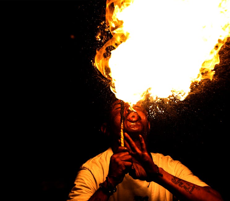 A performer breathing fire at night