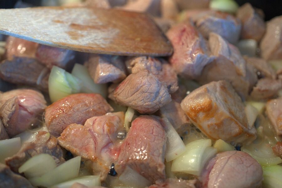 A bowl of Hungarian goulash with onions and meat