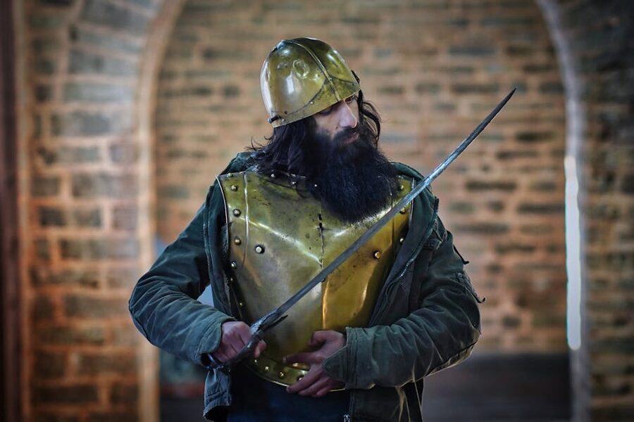 A medieval knight in protective armor holding a sword