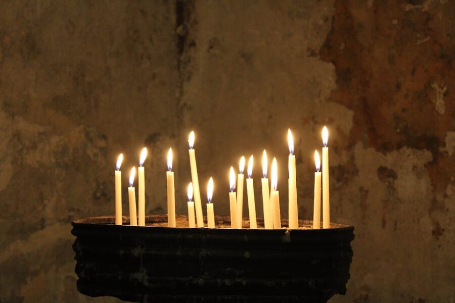 Candles flickering against a textured stone wall in a medieval-style cellar