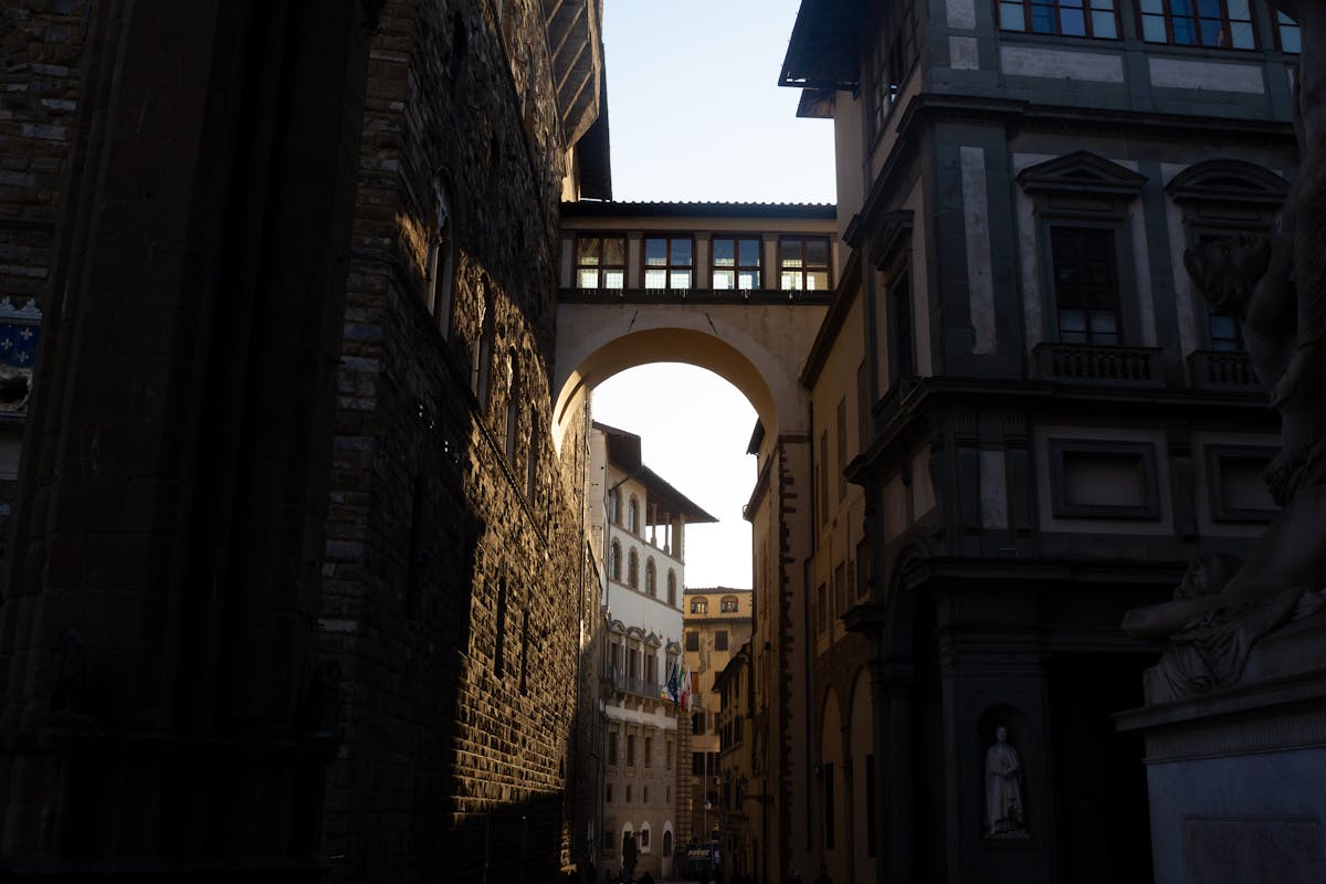 Looking through the arched corridor of the Uffizi Gallery toward the Arno River in Florence
