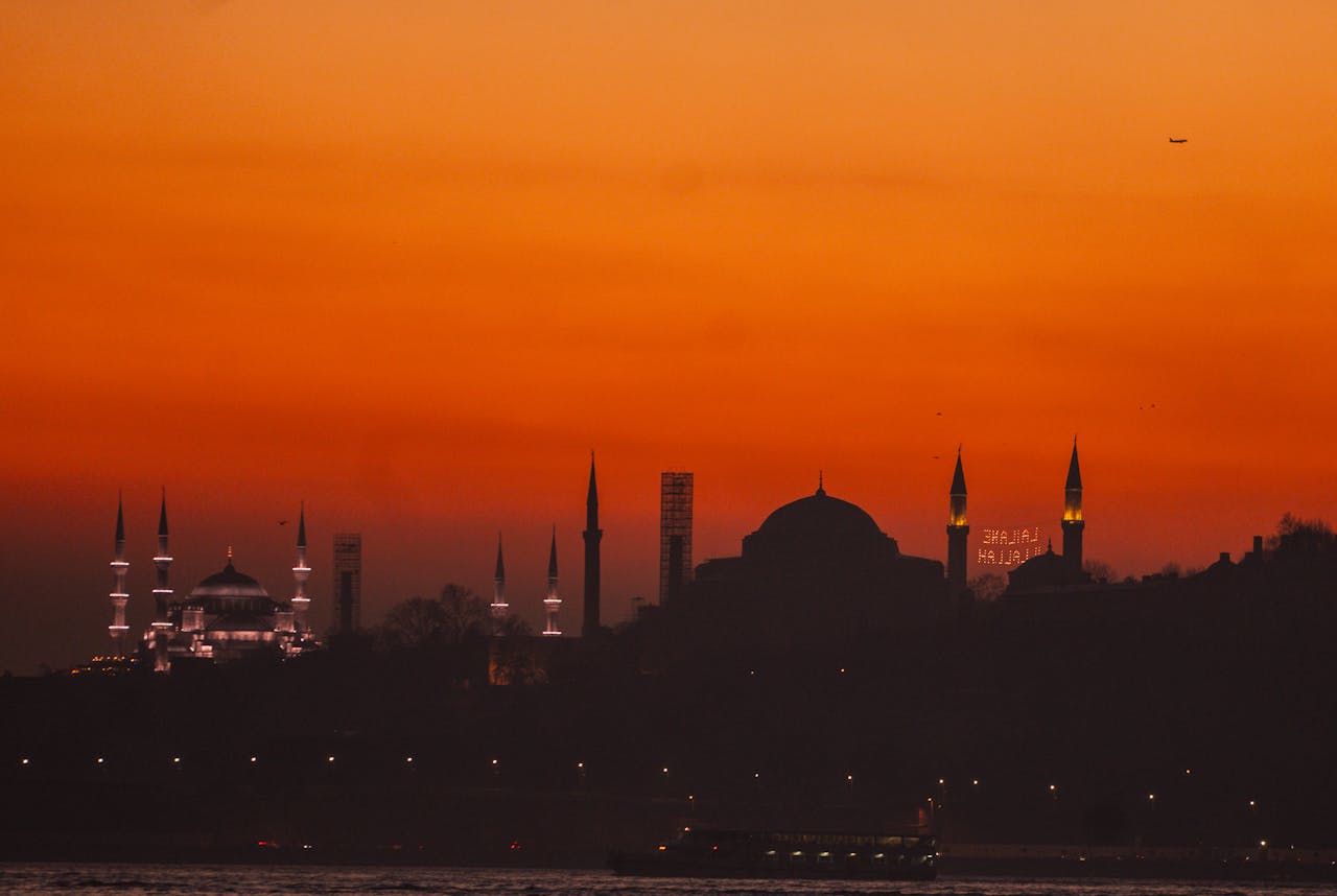 Silhouette of Istanbul's mosque-studded skyline against a deep orange sunset