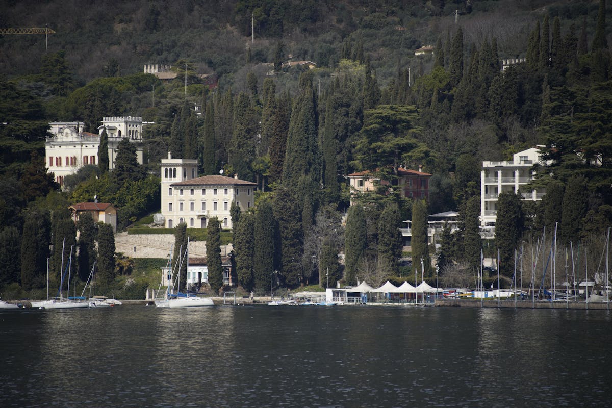 Italian lake villas with boats and lush greenery on a spring day