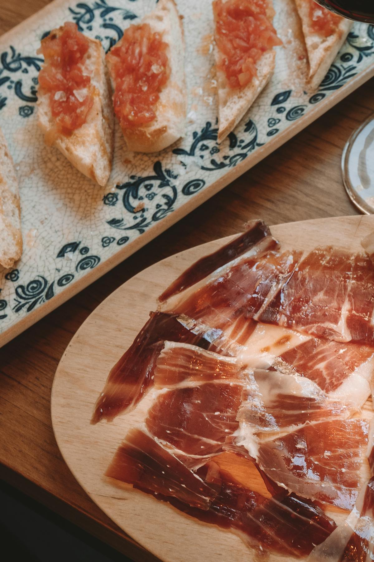 Delicious Spanish tapas featuring Jamon and bread with tomato spread on a ceramic dish