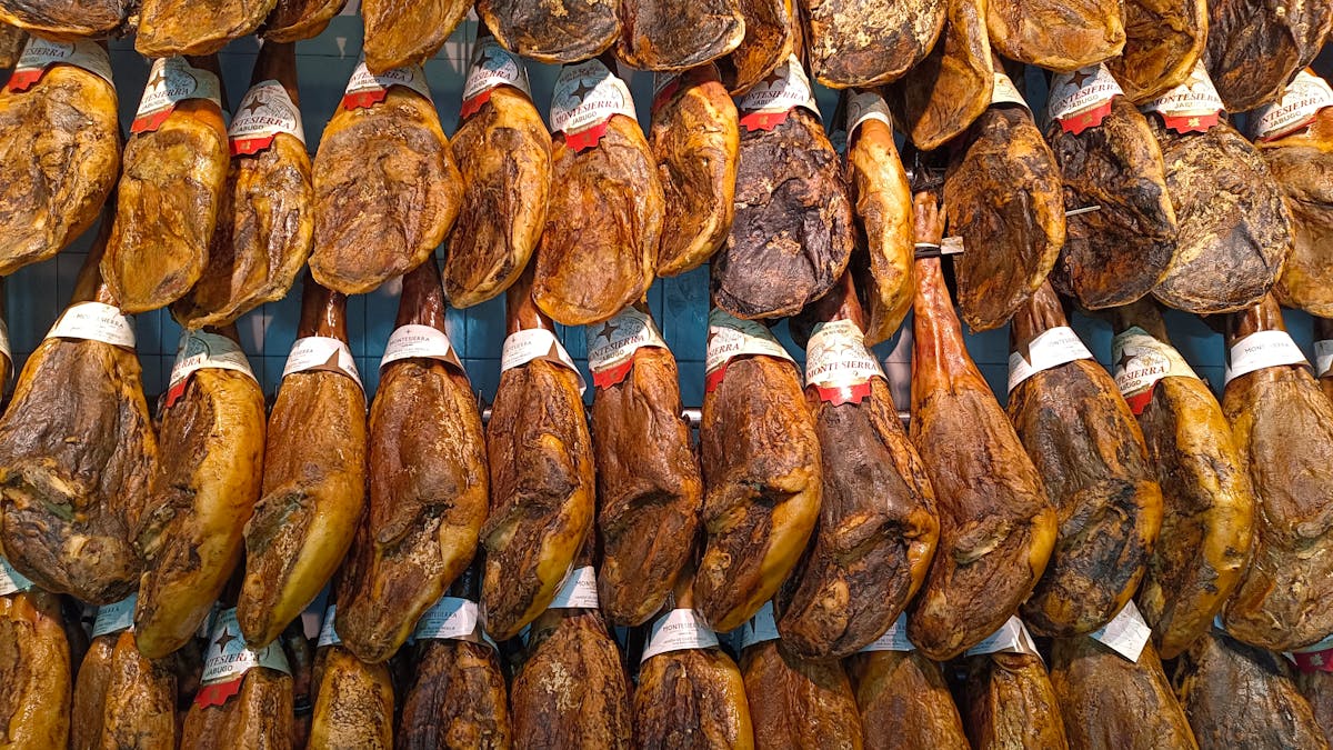 Traditional Jamon Iberico legs hanging in a Spanish market in Seville