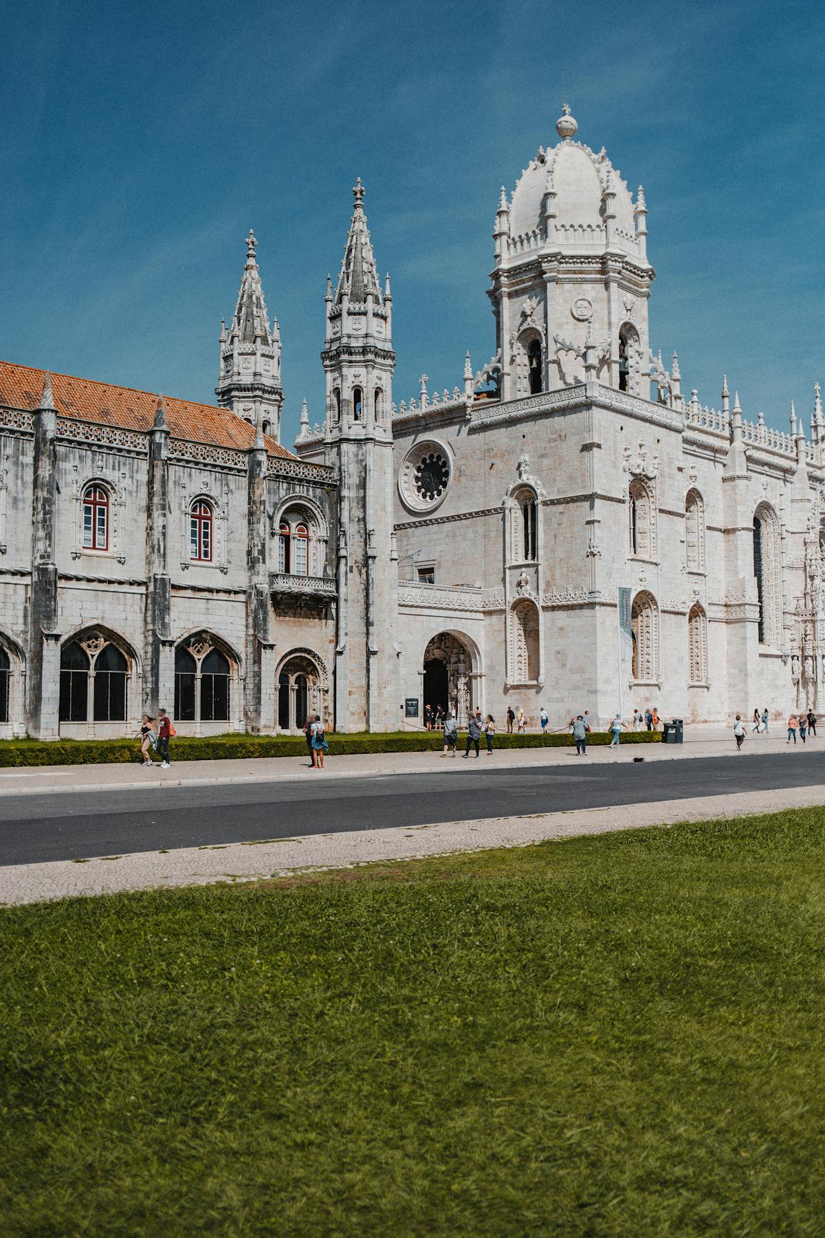The limestone facade of Jeronimos Monastery stretching along Praca do Imperio in Belem