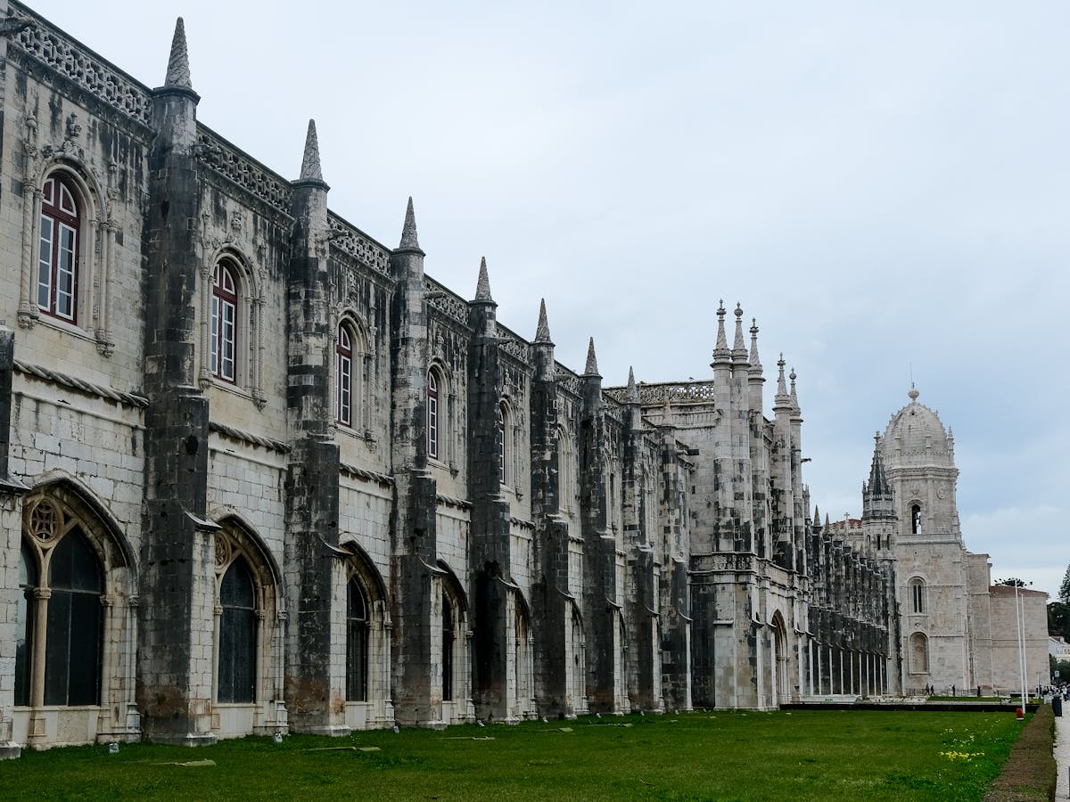 Gothic architecture of the Jeronimos Monastery in Lisbon under overcast sky