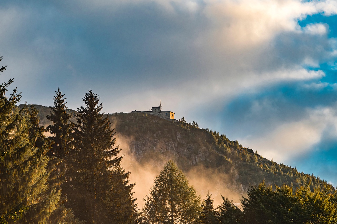 Eagle's Nest building perched on Kehlstein mountain at sunset with fog below