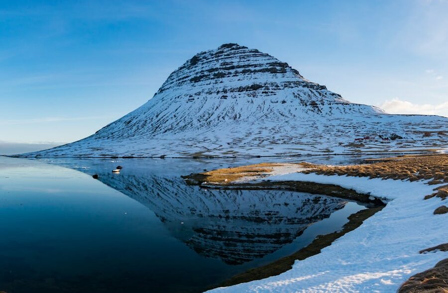 Snow-capped Kirkjufell Mountain reflected in water