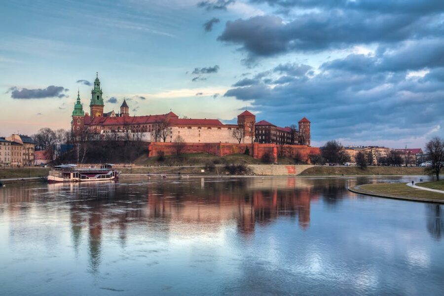 Wawel Castle reflected in Vistula River at sunset