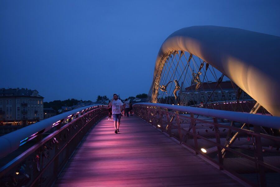 Krakow city bridge lit up at night above the Vistula