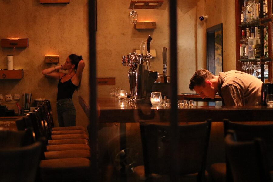 Bartender behind the counter at a Krakow pub at night