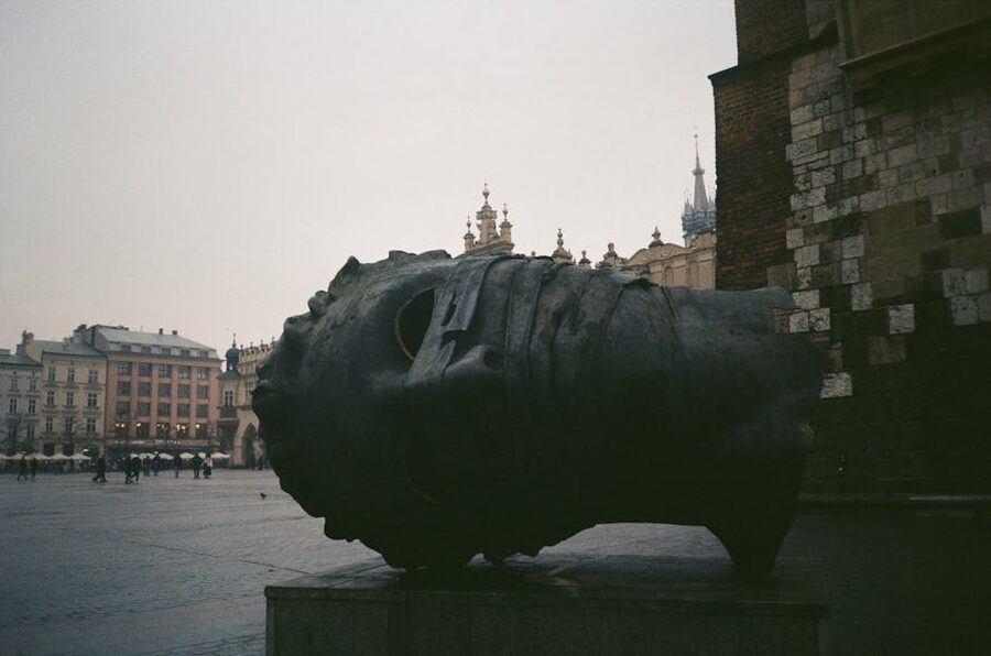 Eros Bendato sculpture in Krakow Main Square at dusk