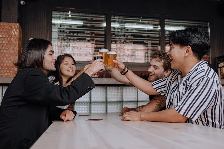Group of friends toasting beer mugs at a cozy bar in Krakow