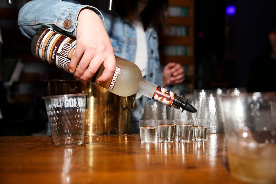 Bartender pouring shots into shot glasses on a Krakow pub crawl