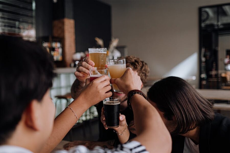 Group of strangers raising drinks in a toast during the open bar hour at a Krakow pub