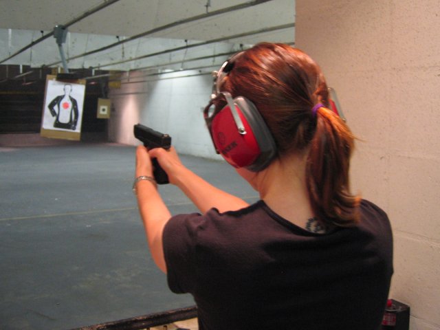 A Glock pistol being held at a shooting range showing proper grip