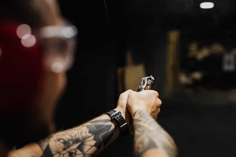 A shooter aiming a handgun down range at an indoor shooting range in Krakow