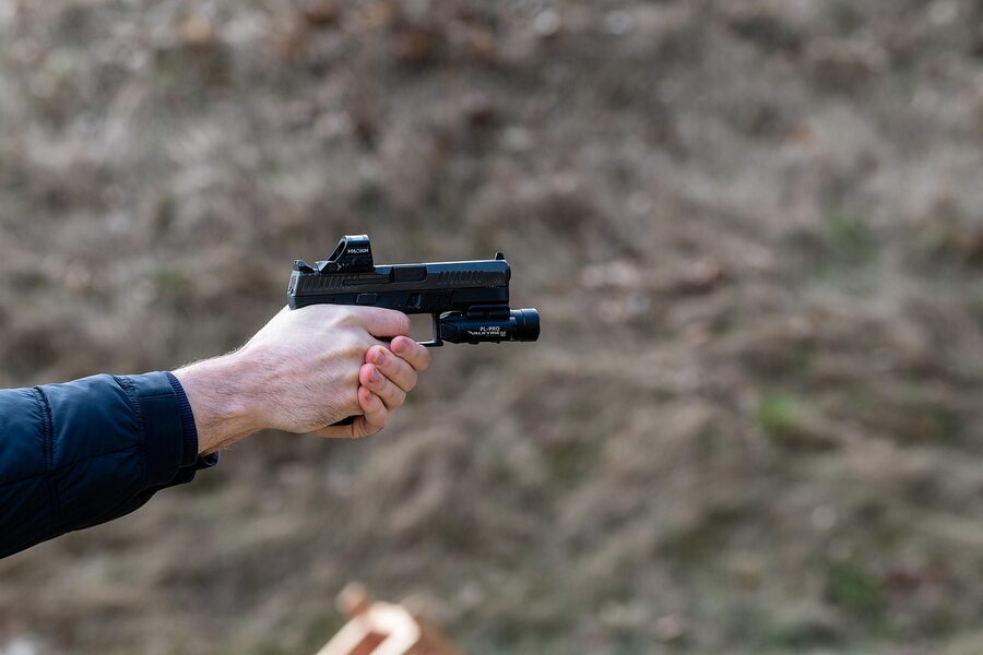A pistol being fired on a Krakow indoor shooting range, showing the muzzle flash