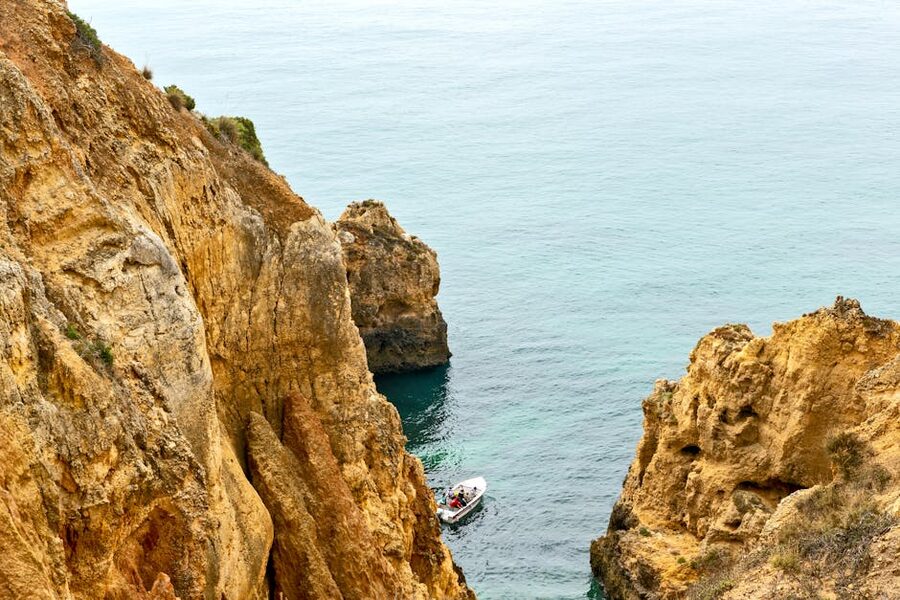 White Lagos tour boat near limestone sea cliff