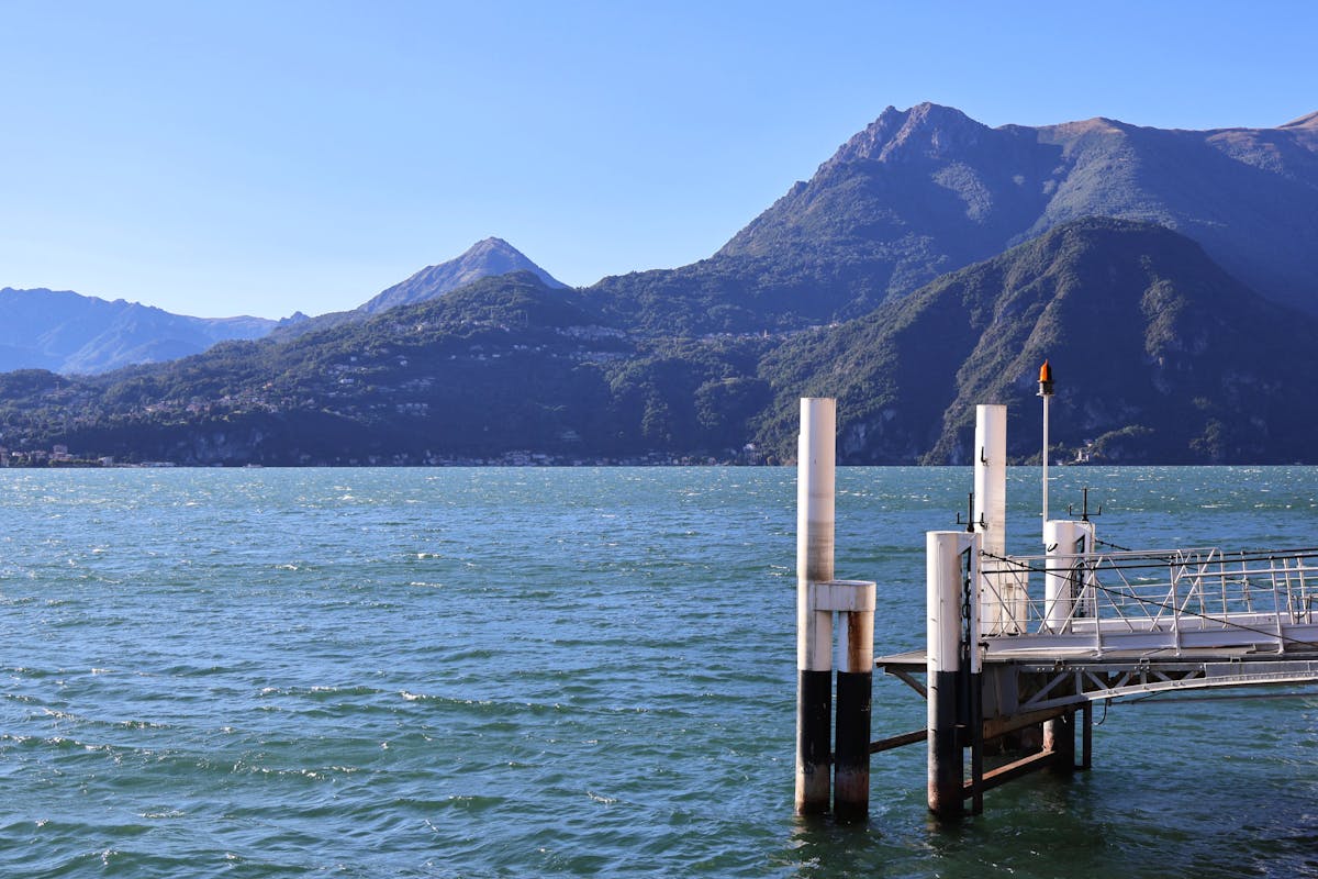 A pier on Lake Como with mountain backdrop on a clear day