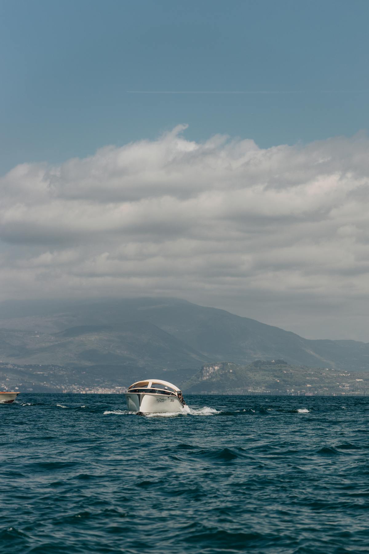Boat crossing Lake Garda with mountains in the background