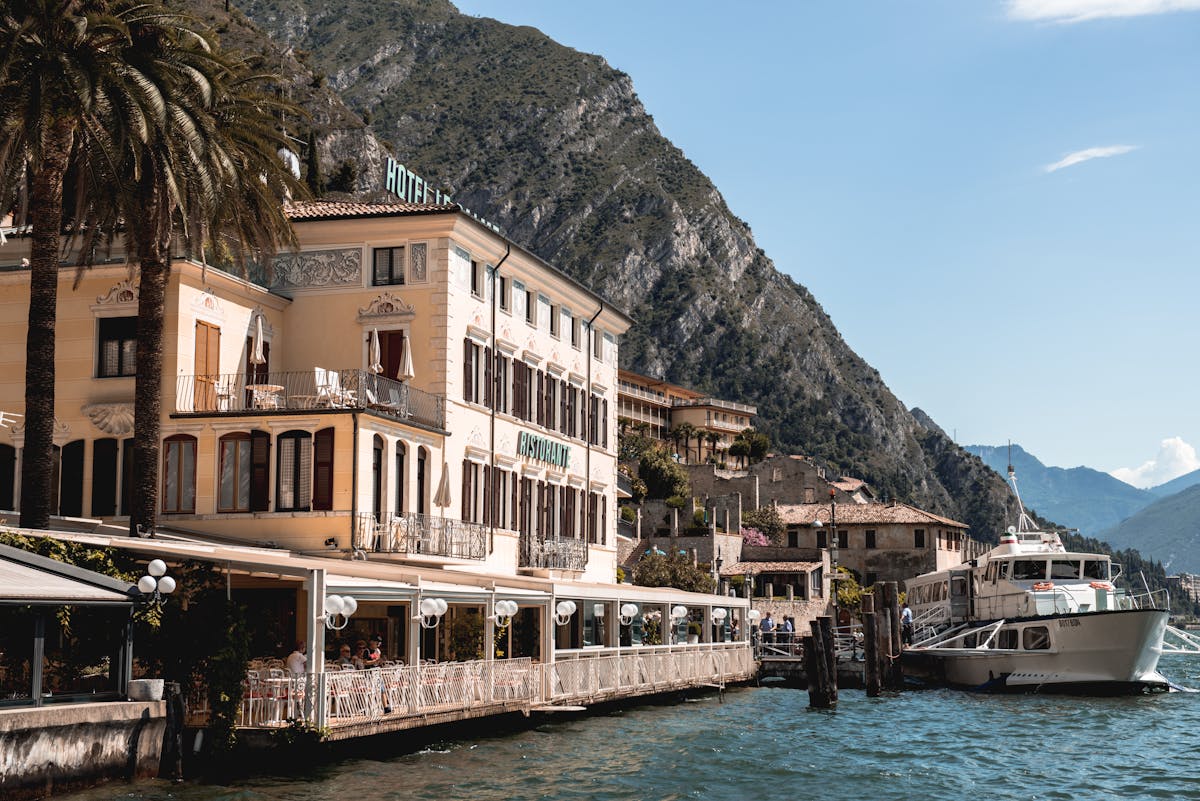Lakefront hotel and restaurant at Lake Garda with mountainous backdrop