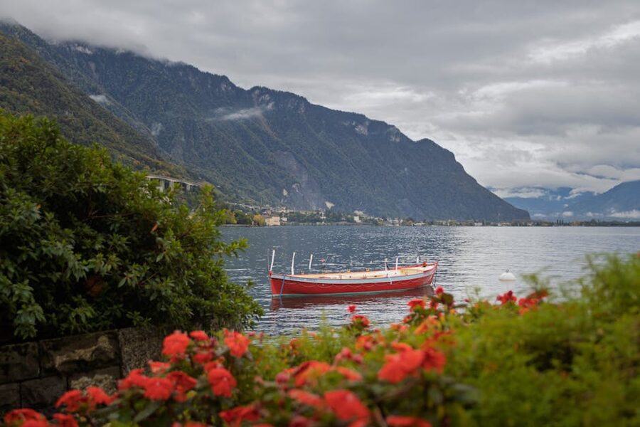 Red boat on Lake Geneva with alpine backdrop