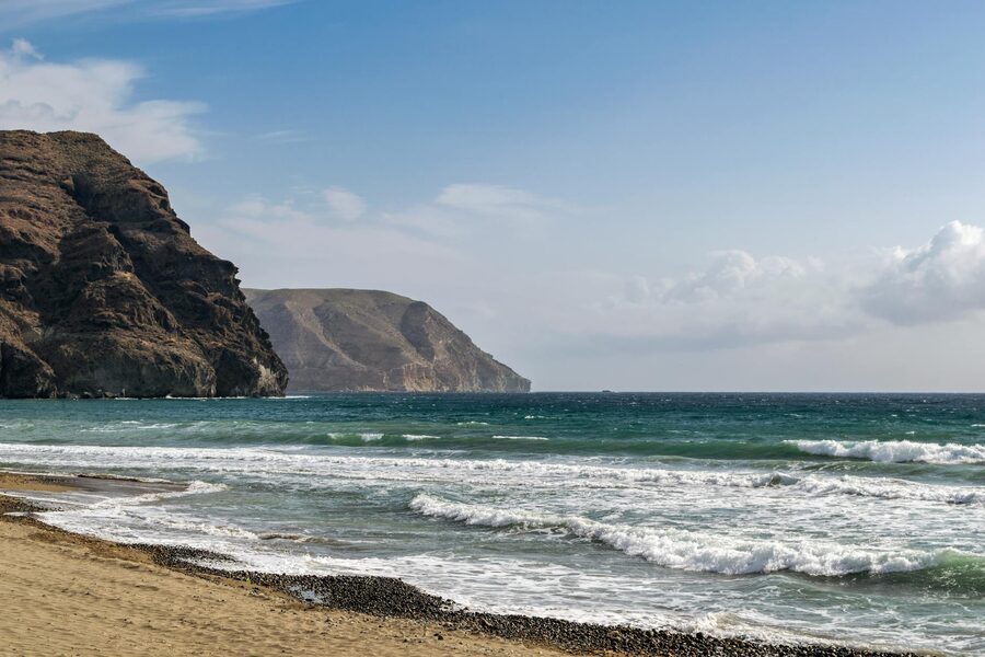 Las Negras beach with waves rolling in and arid hills behind