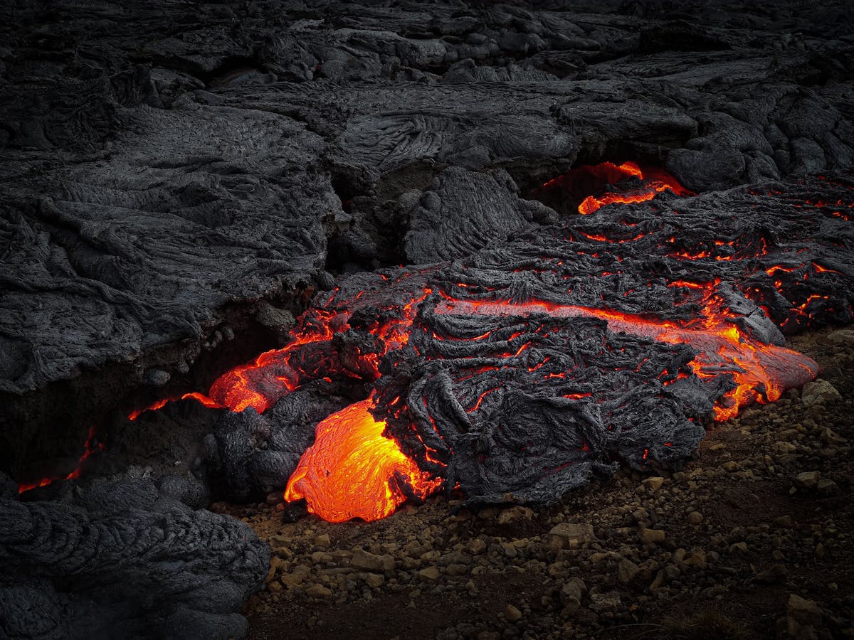 Molten lava flowing over dark volcanic rock