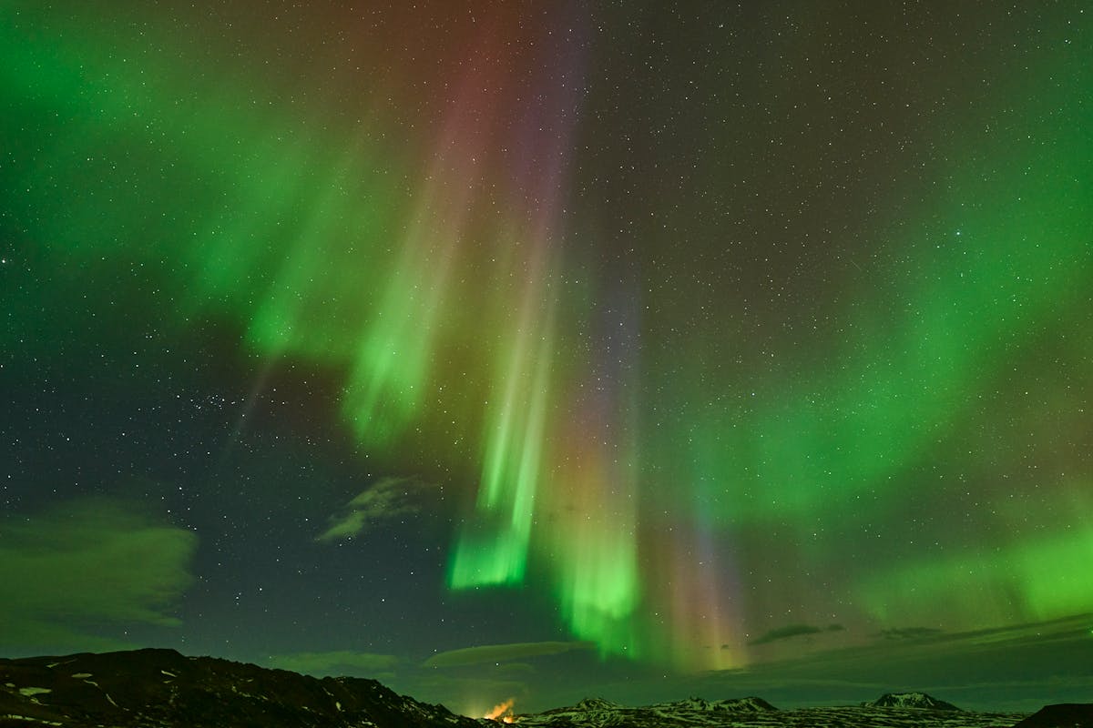 Aurora borealis dancing over Icelandic landscape at night