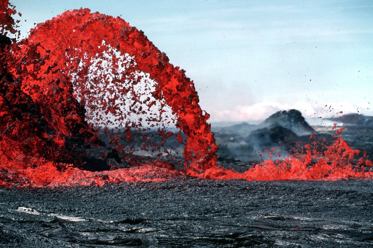 Glowing red and orange molten lava flowing over dark volcanic rock