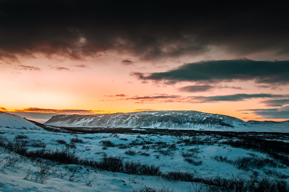 Breathtaking sunset over snowy Icelandic landscape with dramatic clouds