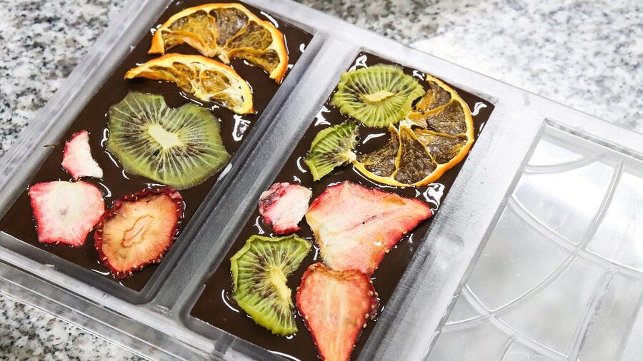 Dark chocolate bar being crafted by hand, showing the chocolate-making process
