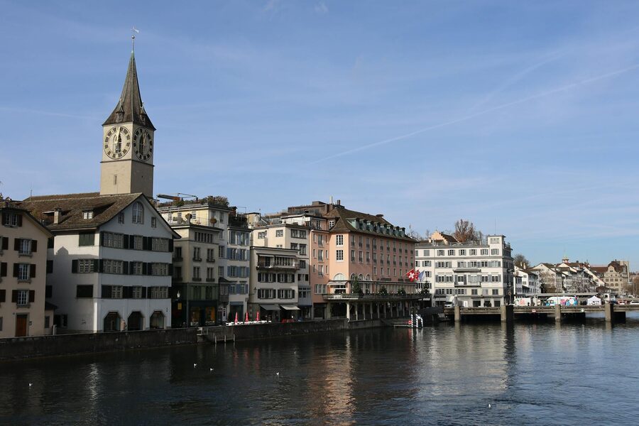 Zurich's iconic clock tower and old town buildings along the Limmat river