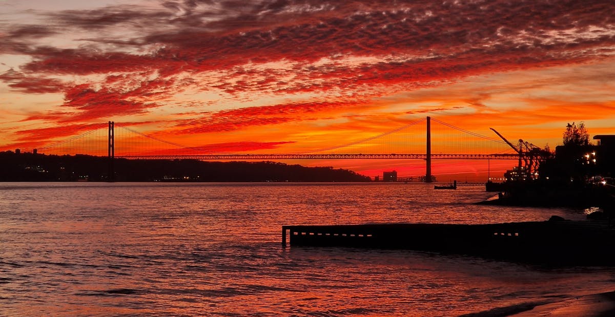 The 25 de Abril Bridge in Lisbon glowing in warm sunset light