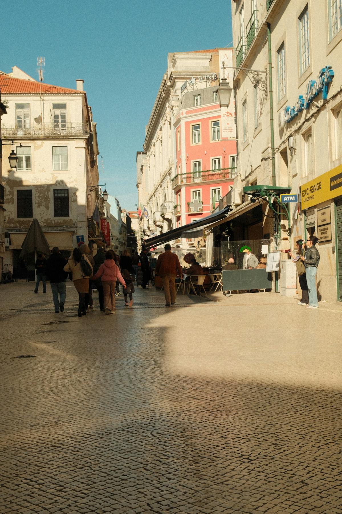 Lisbon street with colorful buildings cafes and people enjoying a sunny day