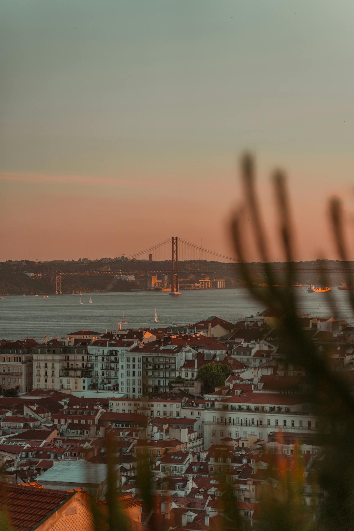 Sunset view over Lisbon skyline with the 25 de Abril Bridge in the foreground