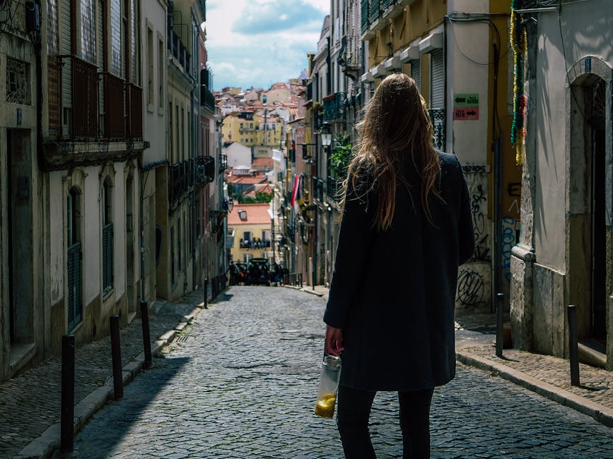 Woman carrying lemons on Lisbon cobblestone street