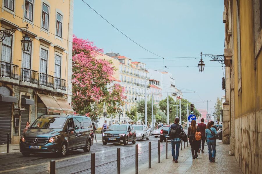 Pedestrians walking on Lisbon street under clear sky