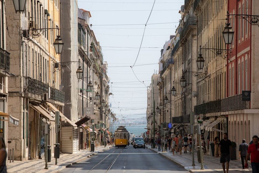 Yellow Tram 28 on historic Lisbon street between buildings